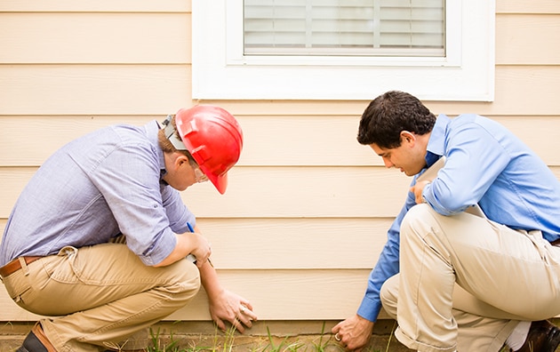Home inspector looking at the exterior of a home